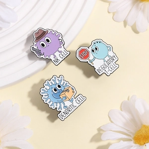 Detailed view of NK cell and T cell enamel pins on a decorative white display tray