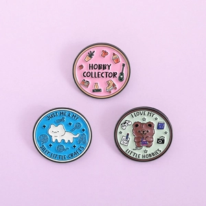 Detail of round enamel hobby collector pins in pastel pink, blue, and green colors