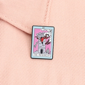 Macro view of pink tarot enamel pin with The Patriarchy text and tower design