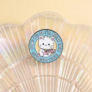 Pin's rond émaillé chat avec masse rose et slogan Paws Off sur fond de coquillage