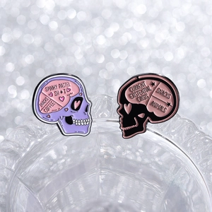 Creepy pastel skull enamel pins with spooky quotes on elegant crystal display