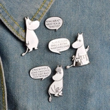 Detail view of Moomin character enamel pins and speech bubbles pinned on denim fabric