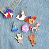 Detailed view of eight circus-themed enamel pins displayed on blue denim fabric
