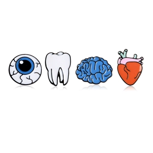 Set di quattro spillette in smalto con occhio, dente, cervello e cuore su sfondo bianco