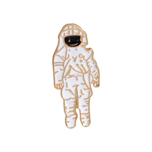 Detailed view of an astronaut enamel brooch with white glaze and gold metal plating