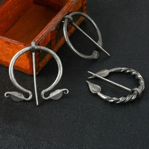 Détail de trois broches vikings vintage en argent avec textures métalliques
