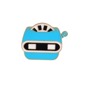Detailed view of an sky blue robot enamel brooch with gold trim and cartoonish design