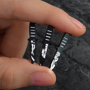Detail showing a set of three punk style black and white enamel knife-shaped pins