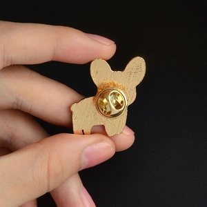 Macro view of gold alloy dog silhouette brooch back with secure butterfly clasp closure
