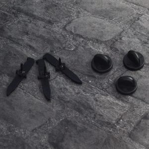 Set of three matte black dagger enamel pins with rubber butterfly backs on stone surface