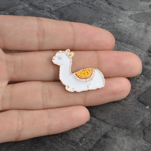 Jolie broche lama en émail blanc avec alliage doré et détails de selle jaune vif