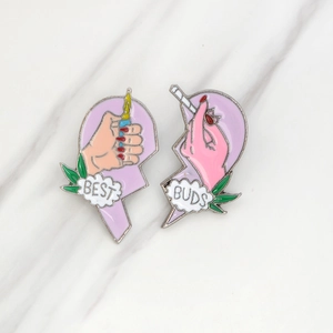 Dettaglio delle spille BEST BUDS a forma di cuore con design accendino e sigaretta