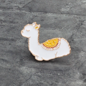 Broche en émail alpaga blanc mignon avec dorure et selle colorée sur fond de pierre