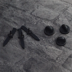 Set of three black enamel punk dagger lapel pins with rubber backings on stone background