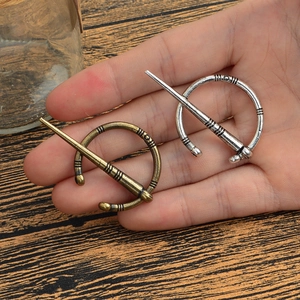 Détail de broches fibules viking en alliage, finitions bronze antique et argent