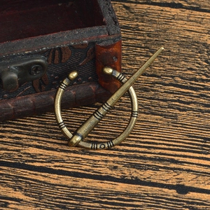 Détail de la broche viking vintage en alliage sur fond de bois rustique