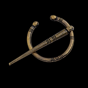 Détail d'une broche Viking vintage en bronze avec finition antique sur fond noir