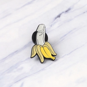 Creative enamel pin badge featuring a funny peeled banana design on marble background