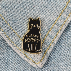 Kreative Emaille-Brosche mit schwarzer Katze und Please Adopt-Text auf Denim-Stoff