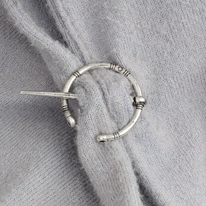 Broche Viking rétro en alliage avec finition argentée sur un châle en tricot bleu
