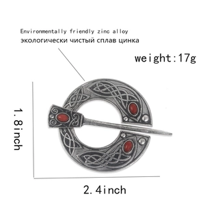 Vintage silver Viking brooch featuring Celtic knot textures and red oval resin gemstones
