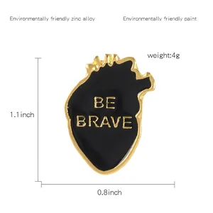 Broche cœur anatomique en émail avec texte BE BRAVE en finition alliage zinc noir et or