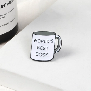 Detail view of World's Best Boss enamel coffee mug pin on minimalist pedestal