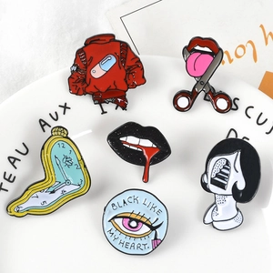 Macro detail of surrealist enamel pins including melting clock and artistic punk designs