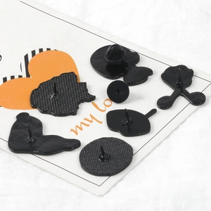 Creative black enamel badges with rubber back pin clasps on a white display card