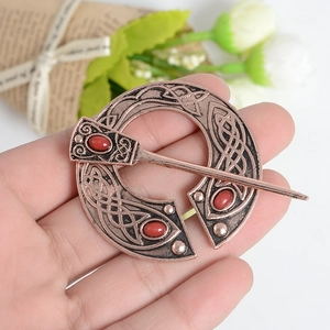 Detail of vintage Viking red ruby brooch with copper Celtic knot pattern and pin clasp