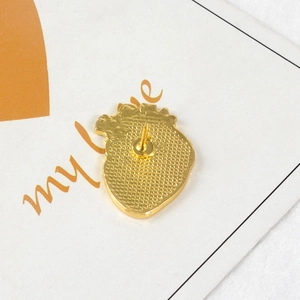Broche cœur anatomique dorée vue arrière avec fermoir papillon sur support blanc