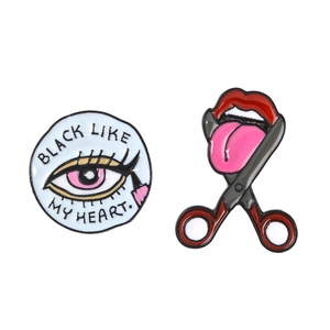 Detail of enamel pin featuring Black Like My Heart phrase and red lips scissor design
