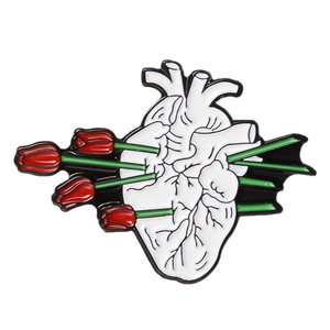 Creative enamel heart brooch with red tulips and green stems on a white background