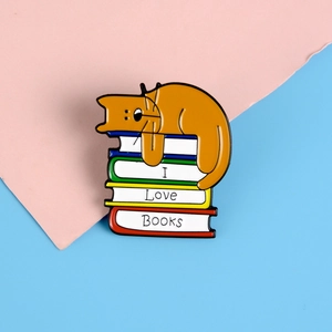 Detailansicht der Emaille-Anstecknadel mit einer Katze auf bunten I Love Books Büchern