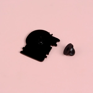 Rückansicht der Katzen-Brosche mit schwarzem Gummiverschluss auf rosa Hintergrund