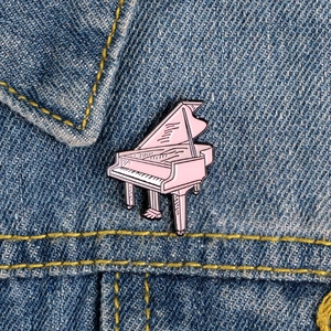 Rosa Flügel Emaille Pin Anstecknadel für Mädchen auf Denim-Stoff Hintergrund