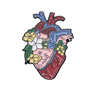 Creative anatomical heart enamel pin featuring colorful flowers and leaves decoration