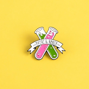 Detailansicht der Chemie-Reagenzglas-Emaille-Anstecknadel mit rosa und grünen Flüssigkeiten