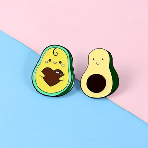 Vue détaillée de deux épinglettes d'avocat en émail avec cœur et sourire sur fond bicolore