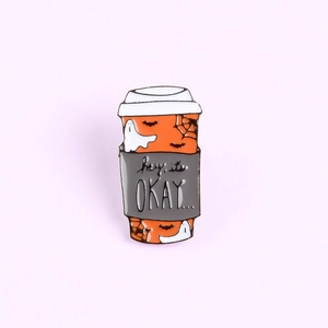 Detailed view of Halloween coffee cup enamel pin with ghost and spider web patterns