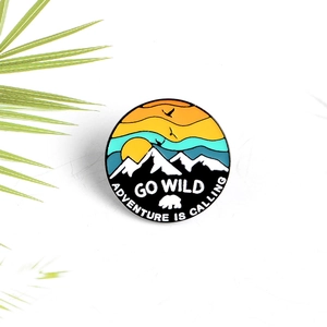 Cartoon enamel hiking pin with sunset mountain scenery and Adventure is Calling slogan