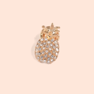 Detailed close-up of a golden pineapple brooch with shimmering crystal rhinestones
