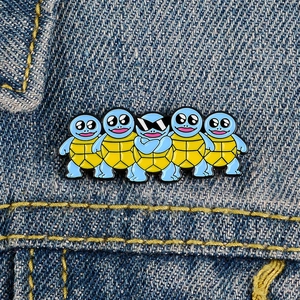 Spille smaltate tartaruga blu con occhiali su denim per decorazione zaino