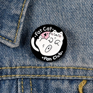 Cute Fat Cat Fan Club enamel pin on denim jacket, black and white cartoon brooch badge