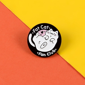 Macro view of Fat Cat Fan Club enamel pin with pink heart detail on vibrant background