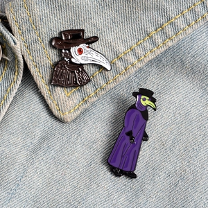Detail view of Plague Doctor enamel pins on a denim collar with artistic bird mask design