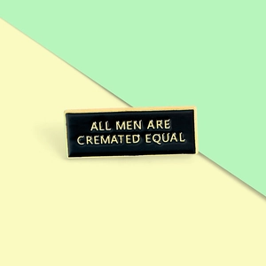 Black and gold rectangular enamel pin featuring All Men Are Cremated Equal text