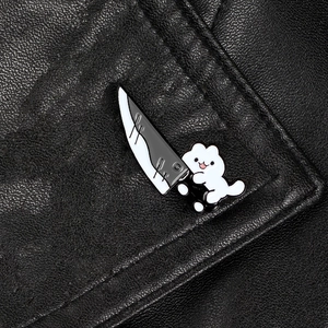 Creative cartoon white cat holding a knife enamel pin on black leather texture background