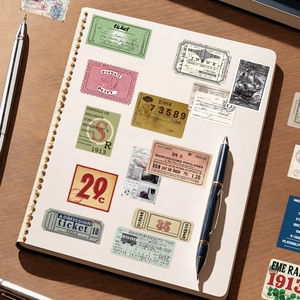 Detail view of vintage aesthetic stickers and tags applied on a beige loose-leaf notebook
