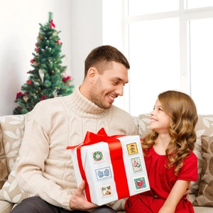 Détails des autocollants de Noël colorés sur une boîte cadeau blanche dans une maison douillette